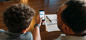 Adult showing a child banking information on a mobile device