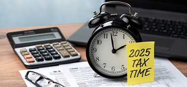 2025 tax season next to clock and calculator